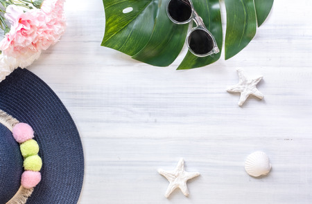 top view of summer blue female hat with sunglasses and shell and star fish decoration on white wood table.summer vacationの写真素材