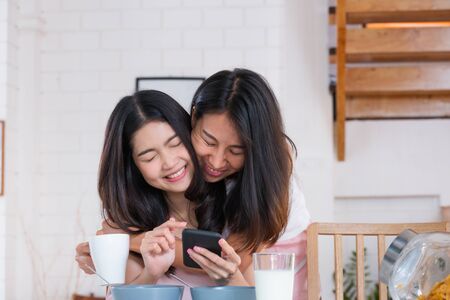 Asian couple lesbian hug each other when have breakfast in morning at home.LGBTQ lifestyle conceptの写真素材