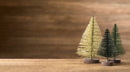 Christmas tree on wood table with wooden wall for merry chirstmas and new year holiday greeting card backgrond. banner mock up with copy space for display productの写真素材