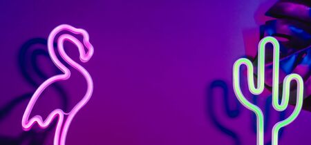 Summer time with pink flamingo, cactus and monstera leaf with neon pink and blue light.Vacation banner mock up space for adding textの写真素材