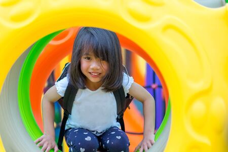 asian kid girl having fun to play on children's climbing toy at school playground,back to school outdoor activity.の写真素材