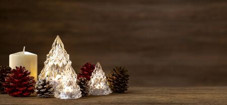 Modern glass Christmas tree with lights on dark wood table with wall for merry chirstmas and new...