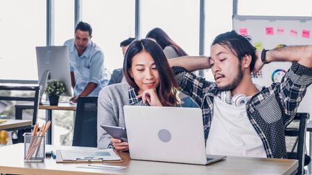 two of creative designer casual meeting with laptop at modern office in morning at desk.casual workplace lifestyle.の写真素材