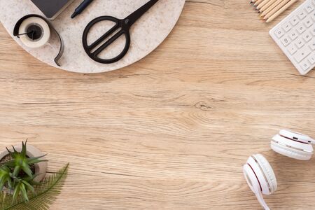 office table desk top view with stationery, notebook,headphone,plant,noteapd and caculator on wooden table flat lay background with copy space. education stuff.craft creator leisure lifestyle backdropの写真素材