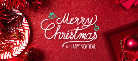 Merry christmas and happy new year red text background.top view of tinsel,gift box,ball,ribbon decorate on sparkling table.holiday celebration greeting card.banner panoramic mockup for display of designの写真素材