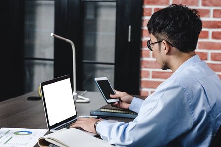 asian businessman woking with laptop and paper work on desk  at office.digital workflow online business lifestyle conceptの写真素材