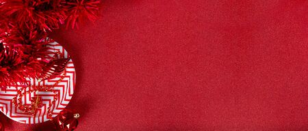Merry christmas and happy new year red background.top view of tinsel,gift box,ball,ribbon decorate on sparkling table.holiday celebration greeting card.banner panoramic mockup for display of designの写真素材