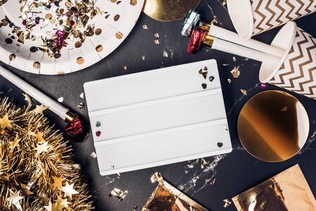 Happy new year party with blank light box with party cup,party blower,tinsel,confetti.Fun Celebrate holiday party time table top view.banner mock up background holidayの写真素材
