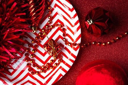 Merry christmas and happy new year red background.top view of tinsel,gift box,ball,ribbon decorate on sparkling table.holiday celebration greeting cardの写真素材
