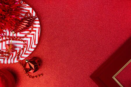 Merry christmas and happy new year red background.top view of tinsel,gift box,ball,ribbon decorate on sparkling table.holiday celebration greeting card.banner mockup for display of designの写真素材