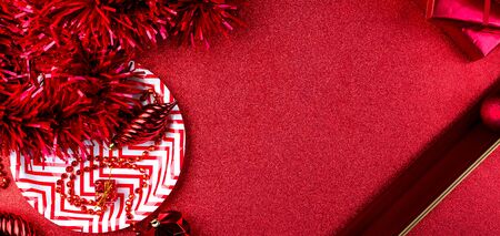 Merry christmas and happy new year red background.top view of tinsel,gift box,ball,ribbon decorate on sparkling table.holiday celebration greeting card.banner panoramic mockup for display of designの写真素材