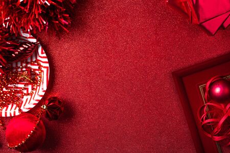 Merry christmas and happy new year red background.top view of tinsel,gift box,ball,ribbon decorate on sparkling table.holiday celebration greeting card.banner mockup for display of designの写真素材