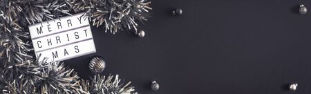 Merry christmas and happy new year lightbox on black table background.top view of tinsel,ball decorate on tabletop.holiday celebration greeting card.banner panoramic for display of designの写真素材