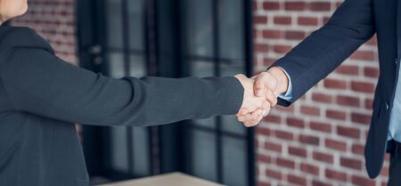 close up hand businessman and businesswoman handshake about business agreement at meeting table in modern office.business partnership concept.satisfied the deal with client negotiation.のイラスト素材