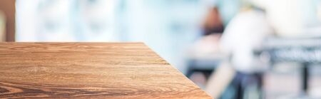 wood table top product display background with blur people in cafe restaurant.left perspective wooden kitchen counter with customer dinning at desk.Banner mockup presentation for your product onlineの写真素材