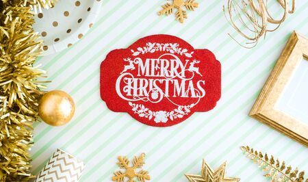 REd Merry christmas lable background.top view of sparkling gold tinsel,ball,ornament decorate on green strip line table.holiday celebration greeting cardの写真素材