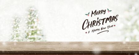 Merry Christmas and happy new year wreath with golden glitter texture over wood table top at blur bokeh christmas tree decor with string light background,Winter holiday greeting cardの写真素材