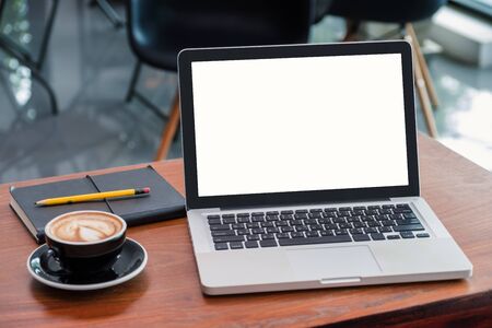 mockup blank screen laptop at coffee shop with notebook on wood table with blur background.modern cafe lifestyleの写真素材
