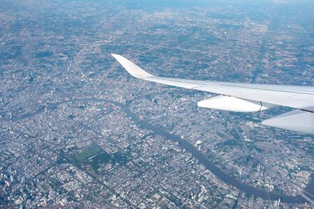 Aerial view of cloud and sky and land with airplane wing from airplane window ,Traveling concept.の写真素材