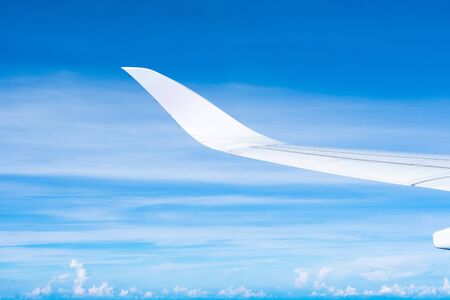 Aerial view of cloud and sky and land with airplane wing from airplane window ,Traveling concept.の写真素材