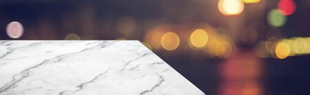 marble table top product display background with blur night cityscape.left perspective stone patio counter with street bokeh lights.Banner mockup presentation for your product on online mediaの写真素材