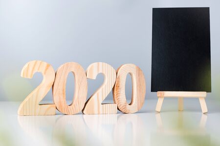 happy new year 2020 with blackboard on white table and grey background. holiday celebrationの写真素材