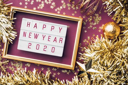 Happy new year light box on purple table background. top view of tinsel, ball, ornament party decorate on tabletop. holiday celebration greeting cardの写真素材