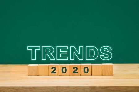 trends 2020 idea on wood cube block on table with green blackboard.business forecasting conceptの写真素材