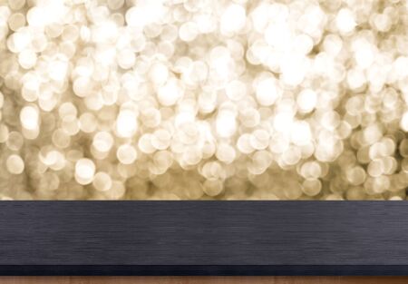 Empty old rustic black wood table top with blur sparkling gold bokeh background,panoramic banner for display or montage of product,Holiday seasonal concept backdrop.の写真素材