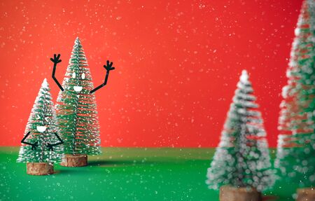 christams tree with smile face emotion doodle style decoration on green table with vivid red background.holiday celebration greeting card with copy spaceの写真素材