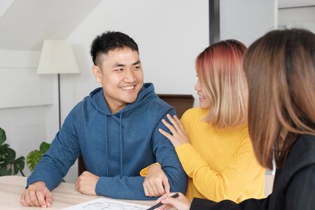 Asian happy couple buying new home with realtor agent with smiling face at new home.buying new house real estateの写真素材