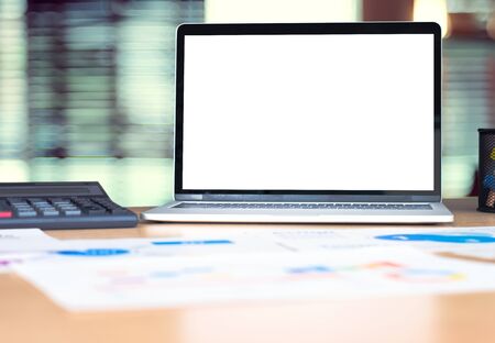 mockup laptop computer screen with business chart market,caculator on desk at blur modern office .device template for display of design.clipping path screenの写真素材