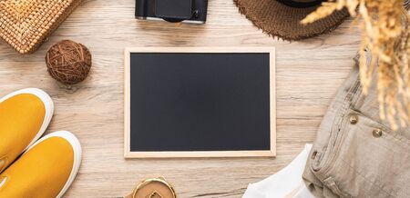 summer travel flat lay of traveller accessories set and blackboard on wooden table with copy spaceの写真素材
