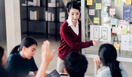 ux developer and ui designer hand up asking question boss about mobile app interface design on whiteboard in meeting at modern office.Creative digital development mobile app agencyの写真素材