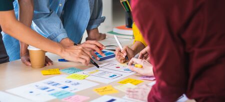 Close up ux developer and ui designer brainstorming about mobile app interface wireframe design on table with customer brief and color code at modern office.Creative digital development agency.panningの写真素材