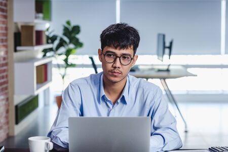 asian businessman woking with laptop and paper work on desk  at office.digital workflow online business lifestyle conceptの写真素材