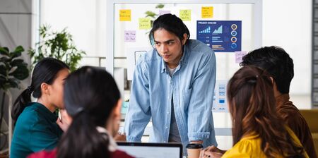 asian ux developer and ui designer brainstorming about mobile app interface wireframe design on...