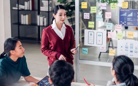 asian ux developer and ui designer presenting mobile app interface design on whiteboard in meeting at modern office.Creative digital development mobile app agency.digital transformationの写真素材