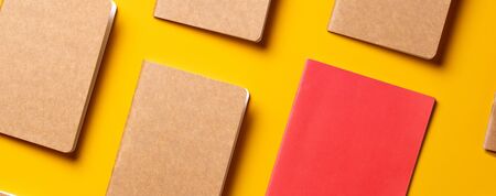 creativity content marketing concept,.top view of red notebook align in pattern on yellow table background.mockup for advertise content online.unique ideaの写真素材