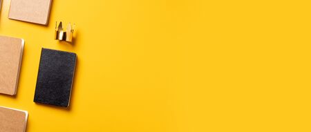 content is king for online marketing concept.top view of notebook with golden crown align with kraft book on yellow table background.banner space for adding contentの写真素材