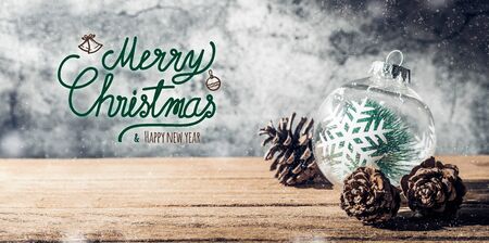Merry Christmas and happy new year sign with Christmas tree  bauble and pine cone on wood table with concrete wall for celebrate holiday greeting card backgroundの写真素材