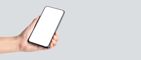 mockup hand holding mobile blank screen on grey background.mockup banner display of content to advert on media.の写真素材