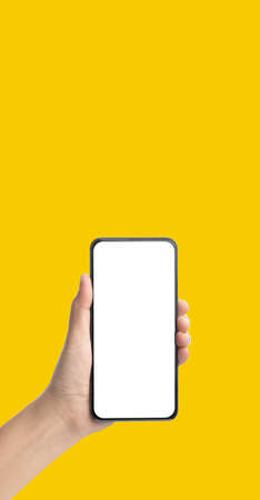 mockup hand holding mobile blank screen on yellow background.mockup banner display of content to advert on media.の写真素材