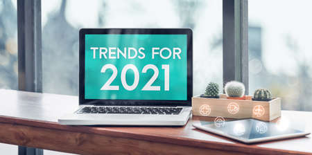 Trends for 2021 in laptop computer screen with icon floating on tablet on wood stood table in at window with blur background,Digital Business or marketing trendingの写真素材