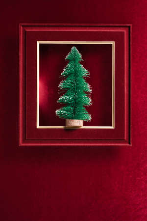 Merry Christmas and happy new year text and Christmas tree in felt photo frame on velvet red felt fabric  top view backgroundの写真素材