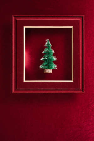 Merry Christmas and happy new year text and Christmas tree in felt photo frame on velvet red felt fabric  top view backgroundの写真素材
