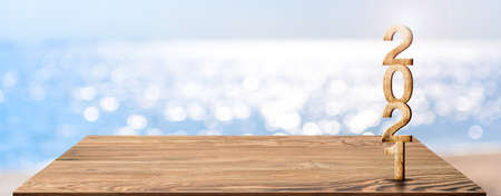 new year 2021 on wood table top with blur blue sky and sea boekh background,summer holiday backdrop.Mock up template for display or montage of product or content use as panoramic bannerの写真素材