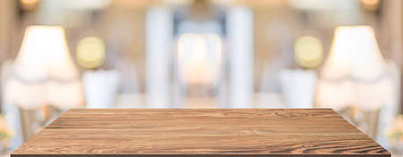 Perspective Wood table at lamp in restaurant blur background.coffee shop with bokeh light,Mockup  banner for display of productの写真素材