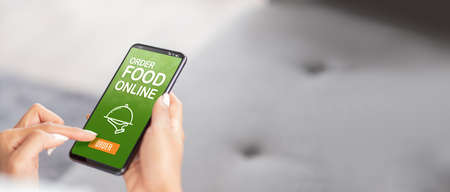 close up woman hand order food online on mobile app at home.online purchase store.online shopping omni channel conceptの写真素材