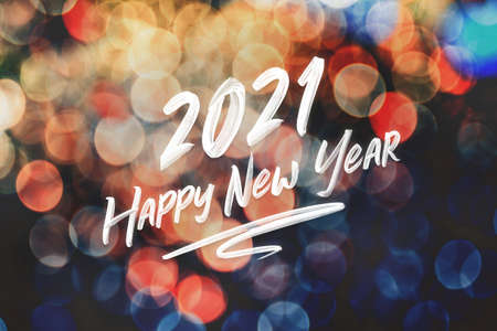 2021 happy new year brush stroke handwriting on abstract festive colorful bokeh light background,holiday greeting cardの写真素材